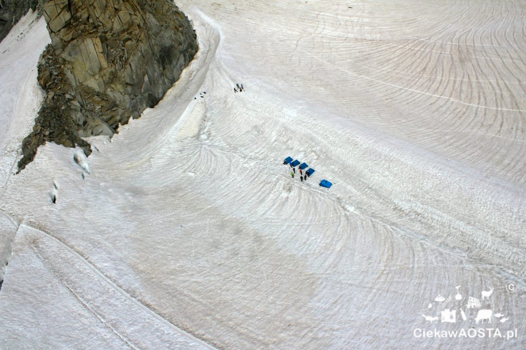 Widok z kolejki Panoramic Mont Blanc na lodowiec i alpinistów. 